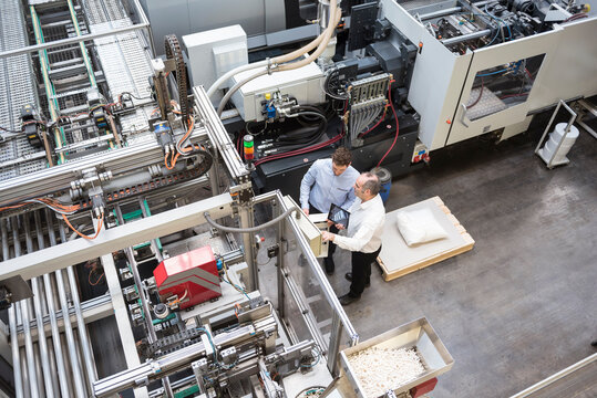 Top view of two men talking in factory shop floor