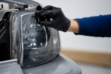 Auto mechanic repairing car headlight lens