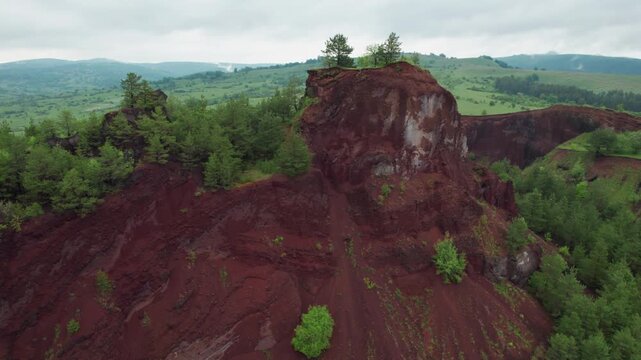 Drone footage flying over the unique red landscape of the Racos extinct volcano in Transylvania