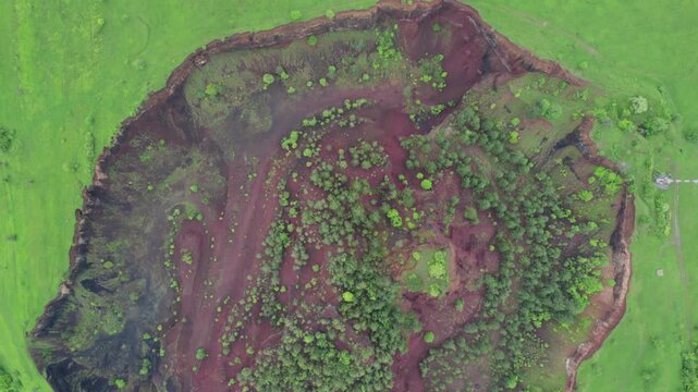 Aerial drone shot showing the unique geological formation of the Racos extinct volcano crater