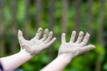 close up of kids hands with mud on it
