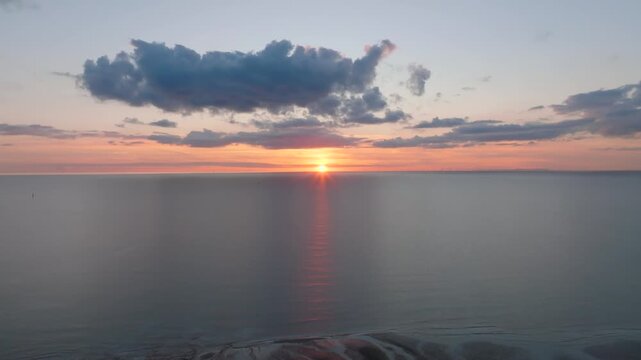 Sunset Over Calm Irish Sea With Reverse Camera Flight Revealing Tidal Sand Flats And Inlets. Golden Hour. Fleetwood, Lancashire, UK.