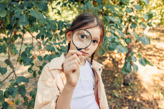 Girl exploring nature with magnifier outdoors showing curiosity