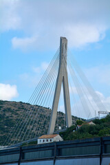 Fototapeta premium Vertical view of the main pylon and steel cables of the Franjo Tudjman Bridge. This modern structure is a key architectural and infrastructure landmark in Croatia.