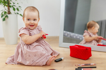 Smiling baby girl playing with makeup kit
