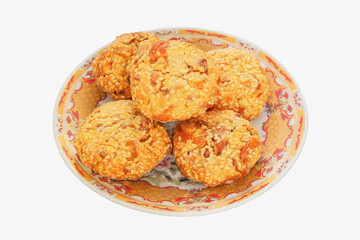 Whole grain cookies with nuts and dried apricots on a white background. Healthy sweets in oriental style. Yellow romantic biscuit. Top view.