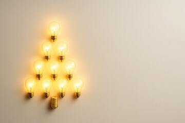 Creative Christmas tree made of glowing light bulbs on soft background with clean space for text festive concept of ideas energy and innovation for business and holiday marketing