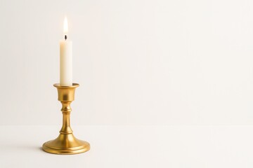 Golden candlestick with white candle on clean background with soft lighting and space for text concept of holiday new year celebration warmth and premium elegance