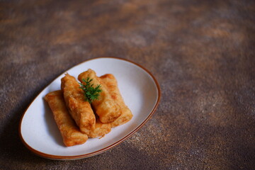 A plate of fried sosis solo in dark background 