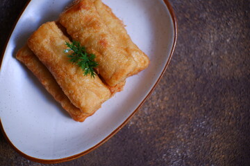 A plate of fried sosis solo in dark background 