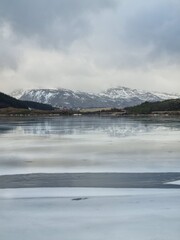 Northern landscape with a crack on the ice. Frozen ice formations in a frozen lake surrounded by an amazing mountain.Lofoten islands, Norway     
