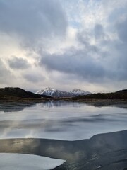 Northern landscape with a crack on the ice. Frozen ice formations in a frozen lake surrounded by an amazing mountain.Lofoten islands, Norway     