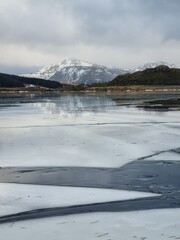 Northern landscape with a crack on the ice. Frozen ice formations in a frozen lake surrounded by an amazing mountain.Lofoten islands, Norway     