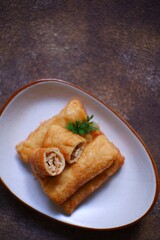 A plate of fried sosis solo in dark background 
