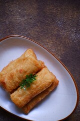 A plate of fried sosis solo in dark background 