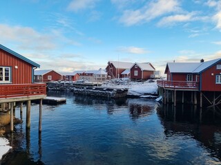 Fototapeta premium Charming winter views of the historic fishing village A (Å) in Lofoten, Norway, featuring colorful wooden buildings, and snowy peaks. 