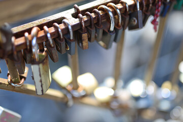 Rusty love locks attached to metal railings on sunny day