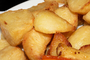 Close up of roasted vegetables crsipy potatoes side dish for Sunday roast dinner