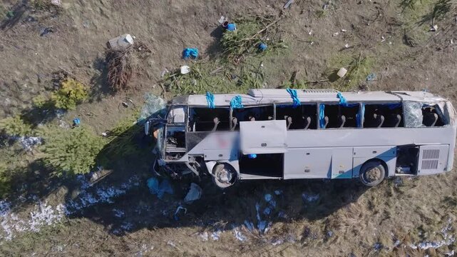 A dramatic 4K aerial drone video capturing the aftermath of a car and bus accident from a perfect 90-degree top-down perspective. The scene reveals emergency response, damaged vehicles/