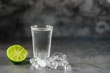 Vodka. Shots, glasses with vodka with ice and lime on gray background