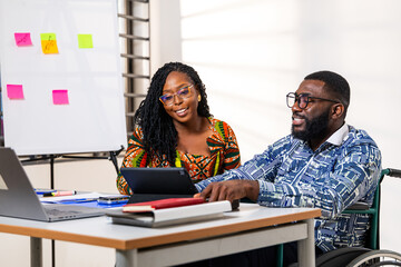 Two African business colleagues collaborating on a digital tablet in the office, brainstorming ideas, engaged in focused work and discussion