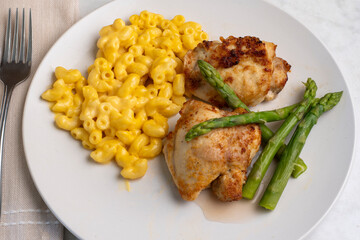 chicken thighs with  macaroni and cheese and asparagus