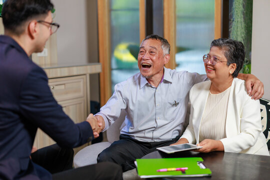 senior asian couple meeting financial advisor in modern office shaking hands after successful business discussion showing trust partnership communication and retirement planning consultation