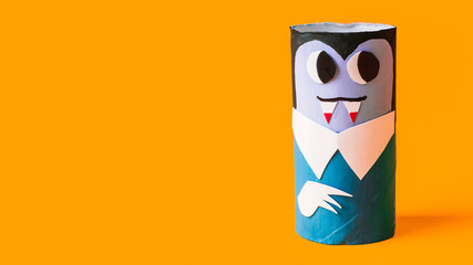 Halloween monsters from toilet paper roll tube, easy DIY handmade decorations idea. Paper toys zombie and vampire on yellow background. Kids creativity, easy eco craft, step by step, place for text