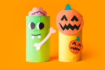 Halloween monsters from toilet paper roll tube, easy DIY handmade decorations idea. Paper toys zombie and vampire on yellow background. Kids creativity, easy eco craft, step by step, place for text
