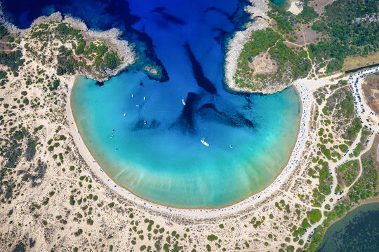 High aerial overhead view of the half circle shaped Voidokilia beach in Messinia, Peloponnese, Greece, with sand dunes and turquoise sea