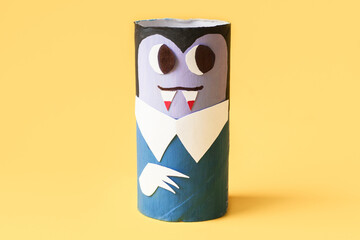 Halloween monsters from toilet paper roll tube, easy DIY handmade decorations idea. Paper toys zombie and vampire on yellow background. Kids creativity, easy eco craft, step by step, place for text