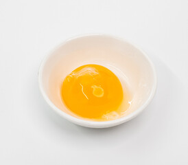 Bright Raw Egg in White Bowl On White Studio Background, Fresh Breakfast Ingredient Photography
