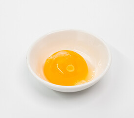 Bright Raw Egg in White Bowl On White Studio Background, Fresh Breakfast Ingredient Photography