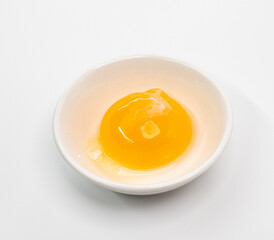 Bright Raw Egg in White Bowl On White Studio Background, Fresh Breakfast Ingredient Photography