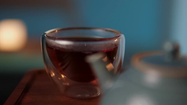 Slow lifestyle and cozy tea ritual pouring hot tea with steam warm light and calm atmosphere