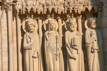 Close-up of religious sculptures on the facade of Notre Dame in Paris with stone-carved figures and Gothic architecture