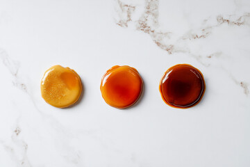 Delicious caramel candy trio in varying shades of golden sweetness, perfect for tempting dessert menus and baking blog posts, a sweet indulgence