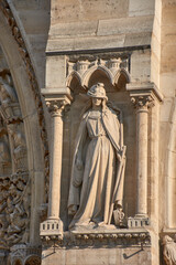 Close-up of religious sculptures on the facade of Notre Dame in Paris with stone-carved figures and Gothic architecture