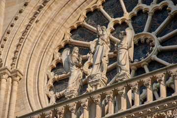 Close-up of religious sculptures on the facade of Notre Dame in Paris with stone-carved figures and Gothic architecture