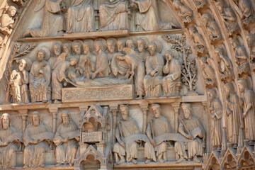 Close-up of religious sculptures on the facade of Notre Dame in Paris with stone-carved figures and Gothic architecture