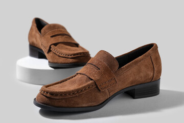 Pair of stylish brown shoes on light background, closeup