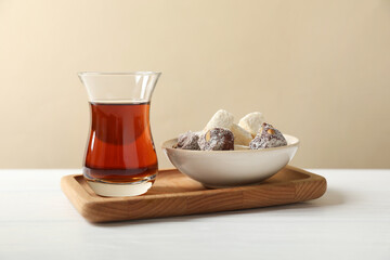 Traditional Turkish tea in glass and sweets on white wooden table