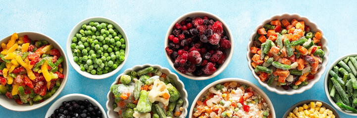 A top view of colorful, frozen vegetables on plates, highlighting the process of preserving summer...