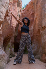 A woman is posing in a cave with leopard print pants