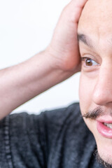 Close-up brown-eyed short-haired man holding head in pain, suffering from headache or stress, concept tension, human emotion, stress thinking, mental health, fatigue, and emotional exhaustion