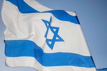 High resolution close up color image of an Israeli flag in the wind with a blue background