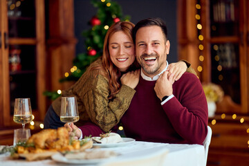 Joyful Couple At A Festive Christmas Dinner With Wine, Warmth, And Holiday Cheer