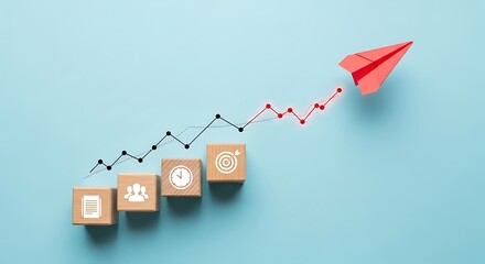 Red paper airplane flying up a rising graph line with wooden blocks showing business icons on a blue background