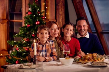 Family Christmas Dinner Celebration With Tree, Candle, and Wine Across Cozy Holiday Table Together Joy