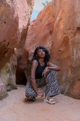 A woman in leopard print pants poses in a cave